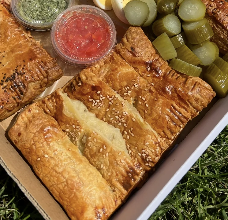 Golden potato burekas with sesame, pickles and dips