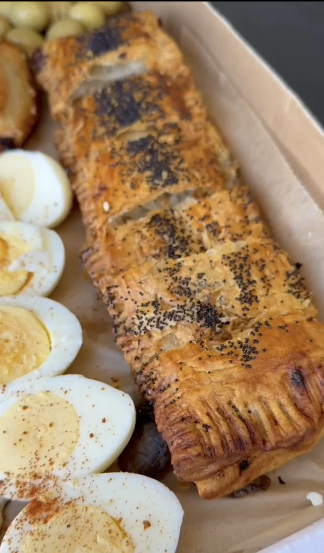 Mushroom and onion burekas in a box with eggs and traditional sides